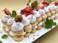 Delizioso tiramisù alle fragole, un dolce a strati con savoiardi, crema rosa e fragole fresche, guarnito con menta.