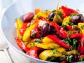 Peperonata ricetta della nonna: un piatto colorato con peperoni rossi e gialli, olive, capperi e prezzemolo fresco.