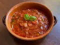 Piatto di pappa al pomodoro in terracotta, guarnito con basilico fresco. Un classico della cucina toscana.