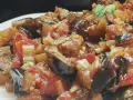 Un piatto invitante di caponata di verdure, con melanzane, pomodori e sedano cotti a puntino.