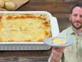 Una teglia fumante di parmigiana di patate, dorata e invitante, con una porzione servita su un piatto.