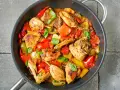 Straccetti di pollo con peperoni rossi e gialli, cotti in padella con basilico fresco.