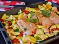 Sovracosce di pollo al forno con patate, zucchine, peperoni e rosmarino, pronte per essere infornate.