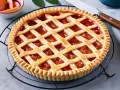 Crostata con pasta frolla per crostata di frutta, ripiena di marmellata di fragole e decorata con strisce di frolla.