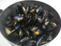 Un saporito sautè di cozze appena cucinato, con gusci aperti che rivelano la polpa succulenta.