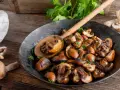 Funghi in padella dorati e saporiti, guarniti con prezzemolo fresco, pronti per essere gustati.