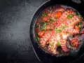 Polpo alla luciana in padella, con pomodorini e prezzemolo. Un piatto succulento e profumato.