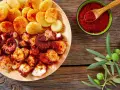 Piatto di polpo alla gallega con patate, paprika e rametto di ulivo.