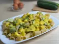 Piatto di rigatoni conditi con una cremosa salsa gialla e zucchine a rondelle, una deliziosa carbonara di zucchine.
