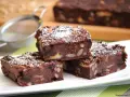 Fette di torta di pane al cioccolato, ricche di frutta secca e noci, spolverate di zucchero a velo.
