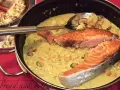Delizioso trancio di salmone in padella con una cremosa salsa gialla e cozze.