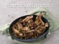 Un saporito coniglio alla ligure, cotto con olive e pinoli, servito in una casseruola verde.
