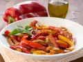 Peperoni in friggitrice ad aria, colorati e succosi, guarniti con basilico fresco.
