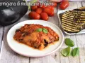 Parmigiana di melanzane grigliate, un piatto saporito con melanzane grigliate, pomodoro e basilico fresco.