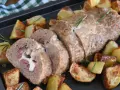 Polpettone al forno ripieno di prosciutto e formaggio filante, servito con patate arrosto e rosmarino.