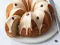 Torta al caffè soffice e profumata, ricoperta da una glassa chiara e decorata con chicchi di caffè. Una fetta è stata tagliata, rivelando l'interno morbido.