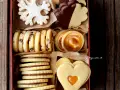 Scatola piena di biscotti al burro: a fiocco di neve, al cioccolato, con ripieno di caramello e a forma di cuore.