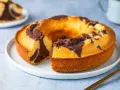 Un ciambellone soffice bicolore, con un invitante contrasto tra pasta chiara e cacao, pronto per essere gustato.