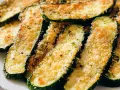 Fette di zucchine al forno, dorate e croccanti, con pangrattato e parmigiano. Un contorno saporito e leggero.