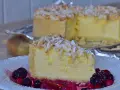 Una fetta di torta di riso cremosa, guarnita con mandorle a lamelle e frutti di bosco, su un piatto bianco.