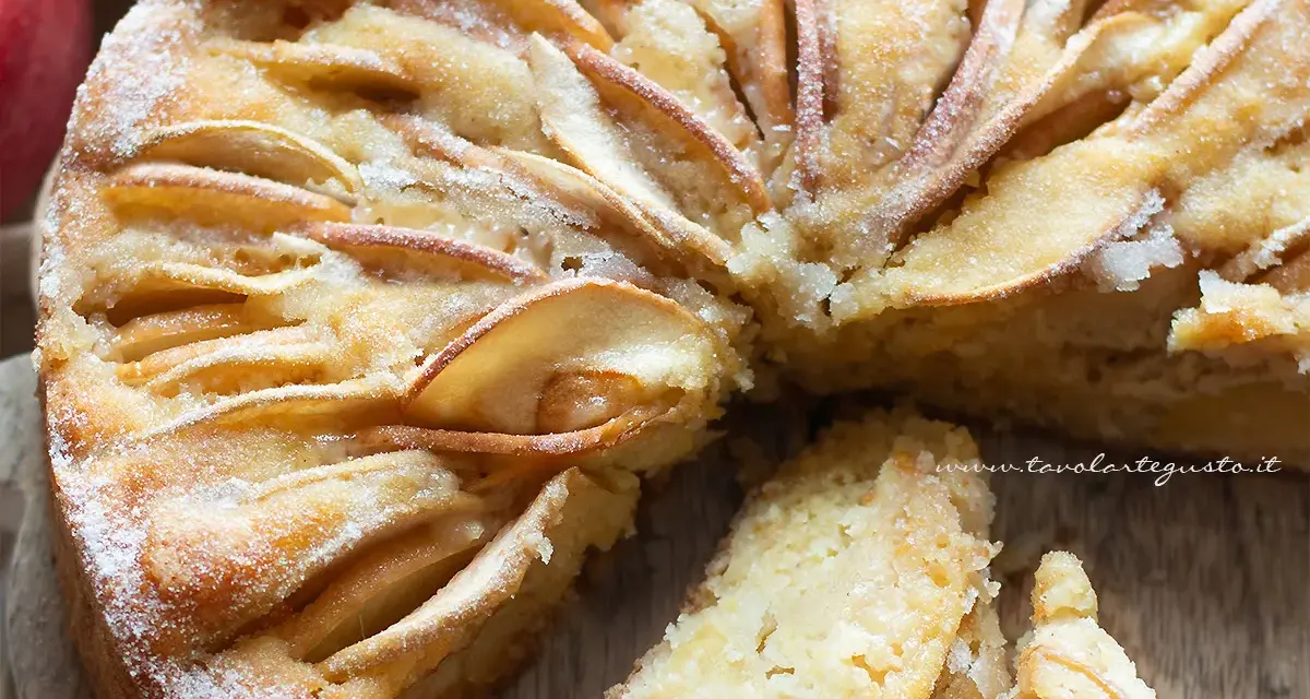 Deliziosa torta di mele senza zucchero, con mele a fettine disposte a raggiera e una spolverata di zucchero a velo.