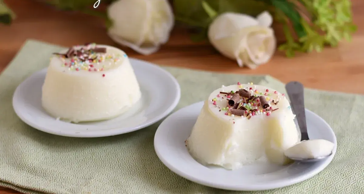 Biancomangiare ricetta originale siciliana: due dolci al cucchiaio bianchi, guarniti con codette colorate e scaglie di cioccolato, su piattini bianchi.