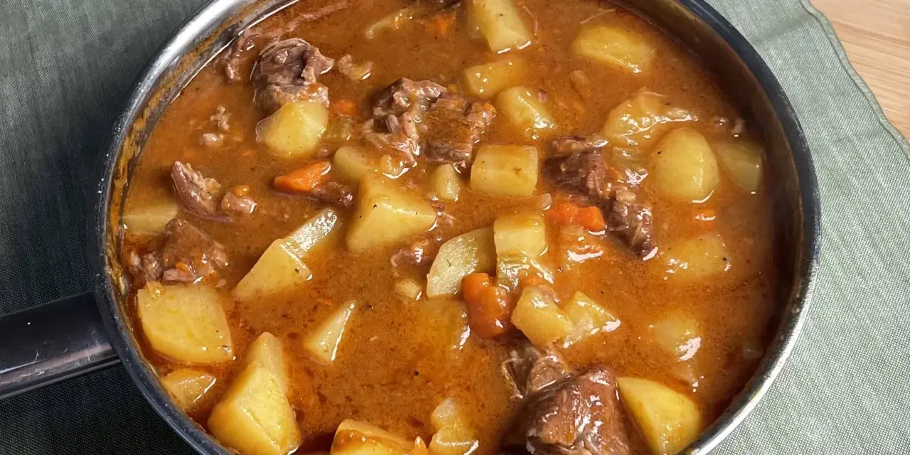 Un invitante spezzatino di manzo con patate e carote in un ricco sugo, pronto per essere gustato.