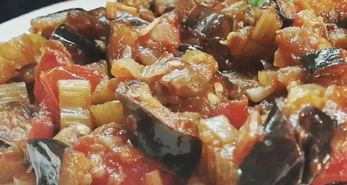Un piatto invitante di caponata di verdure, con melanzane, pomodori e sedano cotti a puntino.