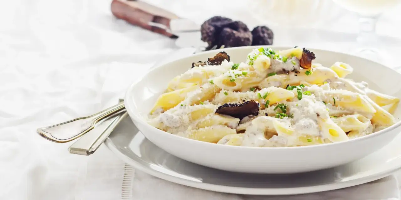 Penne cremose con funghi e tartufo nero, un piatto di pasta alla norcina che invita alla degustazione.