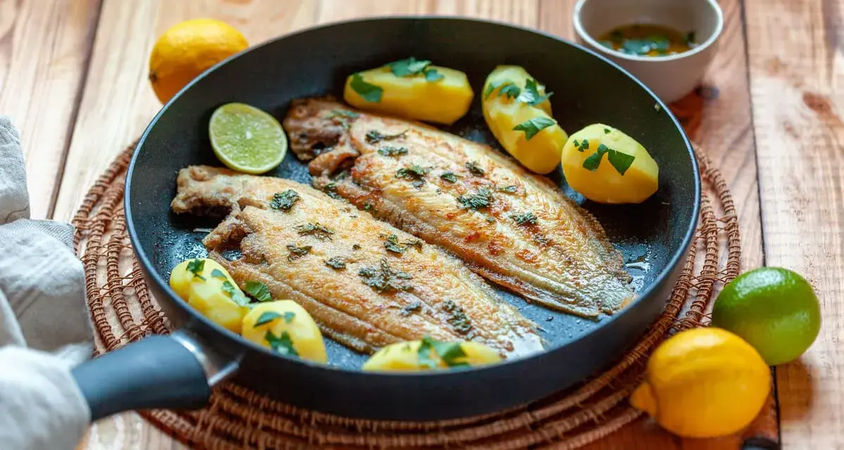 Sogliola alla mugnaia dorata in padella con patate novelle e limone, un piatto semplice e gustoso.