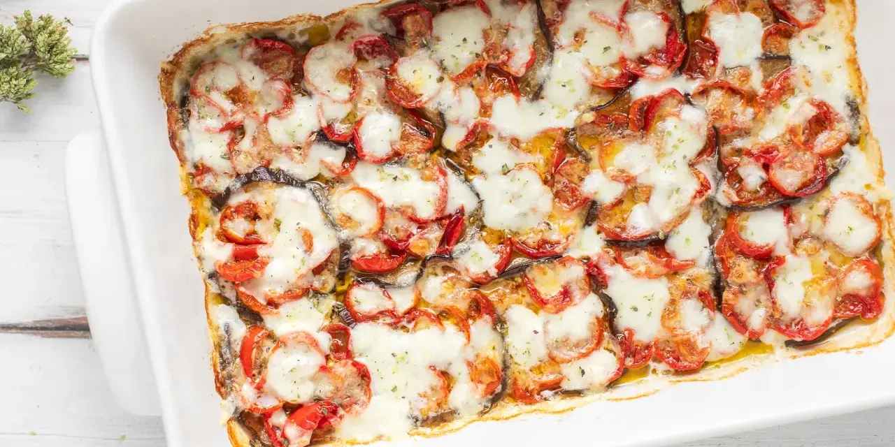 Melanzane grigliate al forno, uno strato invitante di verdure e formaggio fuso, pronto per essere gustato.