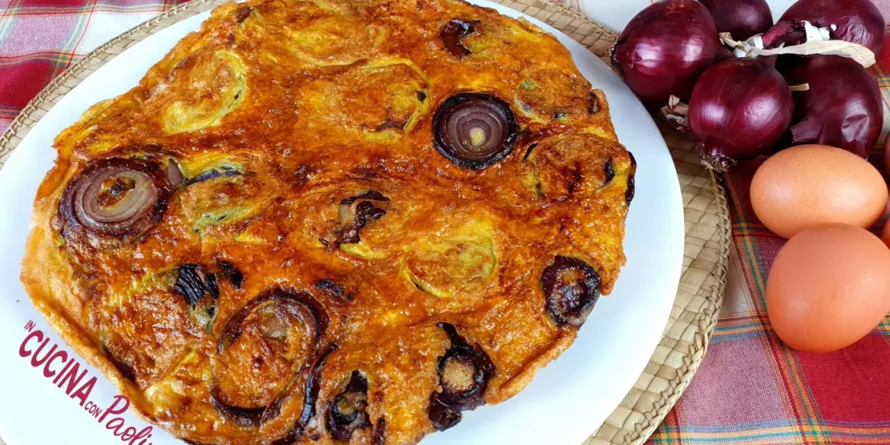 Frittata di pane dorata con cipolle rosse, uova e ingredienti freschi.