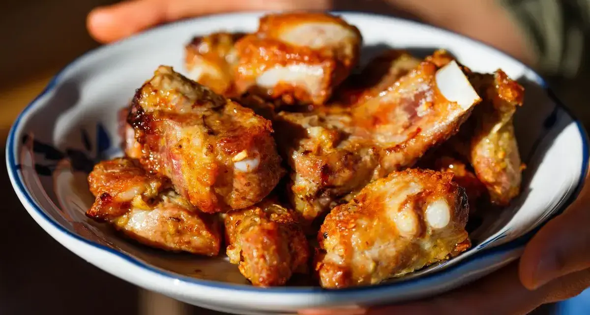 Succulente costine di maiale in friggitrice ad aria, dorate e pronte per essere gustate.