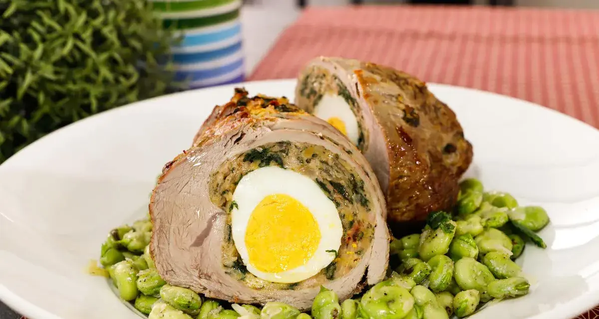 Fettina di carne ripiena con uovo sodo e spinaci, servita su un letto di fave.