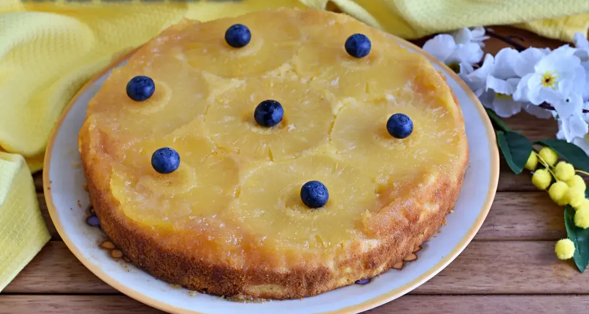 Deliziosa torta rovesciata all'ananas, con fette di ananas caramellate e mirtilli freschi, pronta per essere gustata.