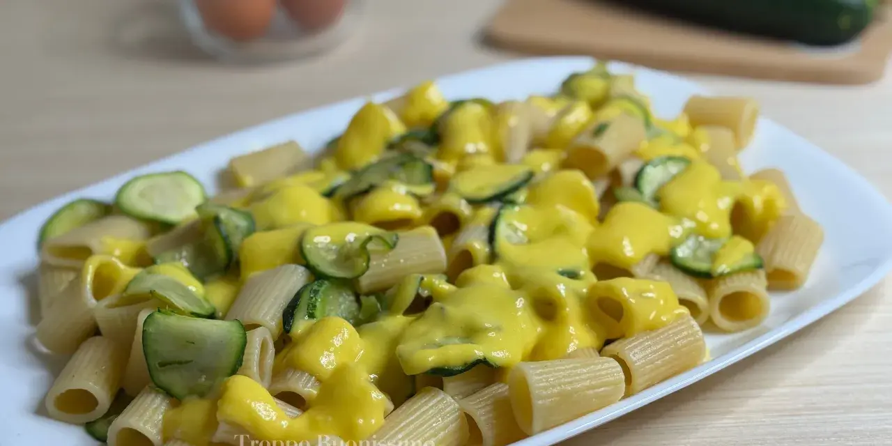 Piatto di rigatoni conditi con una cremosa salsa gialla e zucchine a rondelle, una deliziosa carbonara di zucchine.