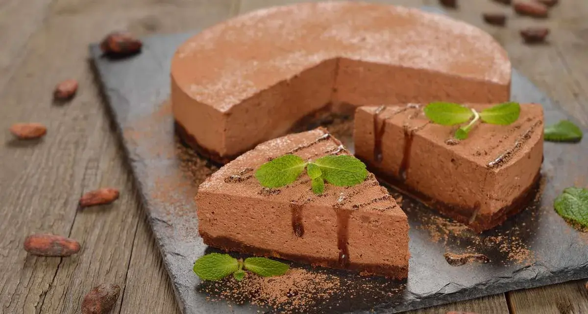 Deliziosa bavarese al cioccolato, cosparsa di cacao e decorata con menta fresca. Due fette sono già state servite.