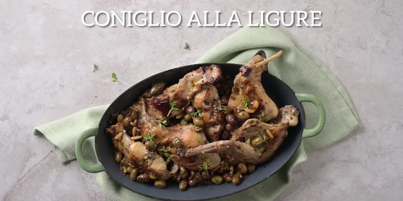 Un saporito coniglio alla ligure, cotto con olive e pinoli, servito in una casseruola verde.
