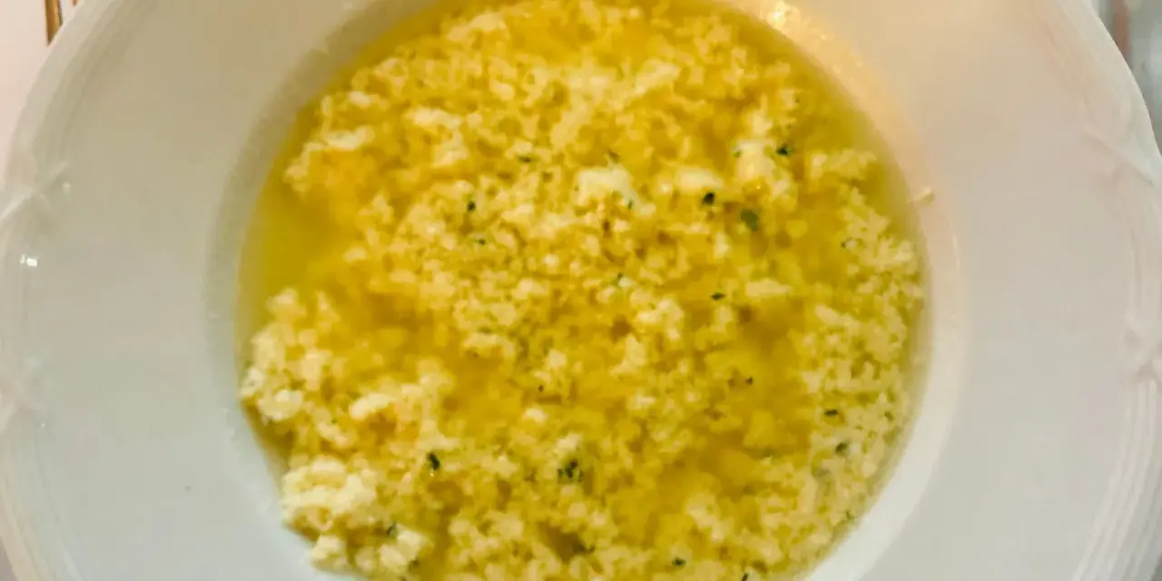 Stracciatella alla romana in una ciotola bianca, un piatto caldo e confortante con uova, parmigiano e prezzemolo.
