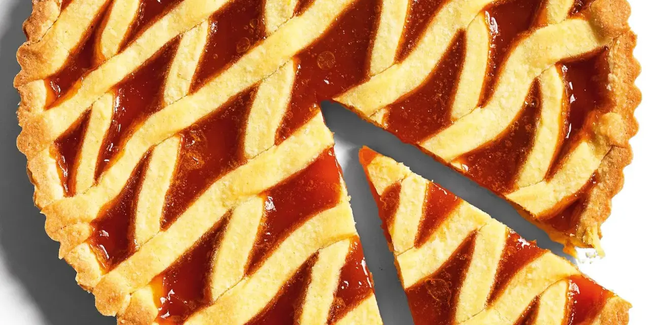 Torta con pasta frolla classica e marmellata, con una fetta tagliata.