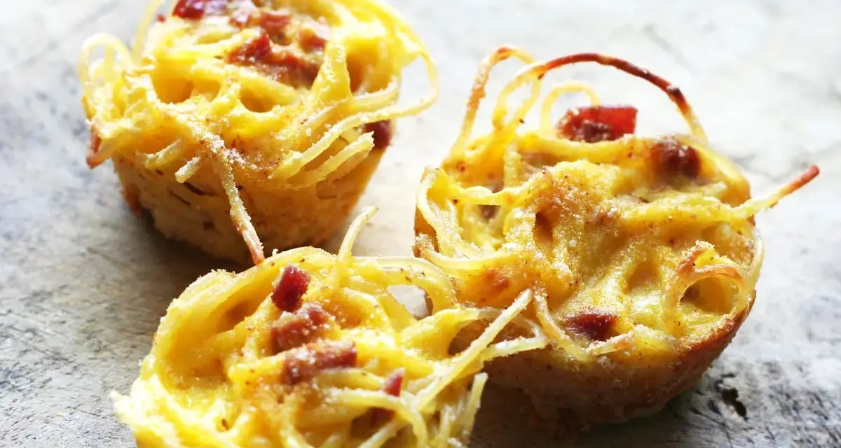 Tre deliziose frittate di pasta, dorate e con pezzetti di pancetta, pronte per essere gustate.