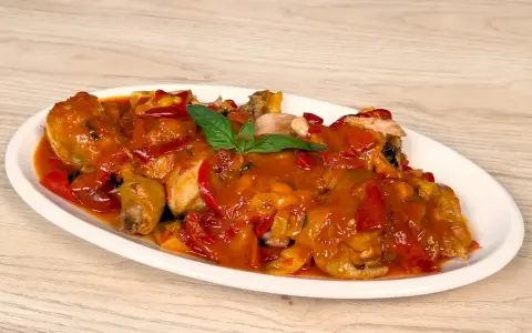 Pollo alla romana succulento, con peperoni rossi e gialli, in un sugo ricco.
