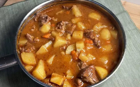 Un invitante spezzatino di manzo con patate e carote in un ricco sugo, pronto per essere gustato.