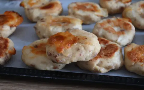 Polpette di pollo dorate e gustose, appena sfornate, con formaggio fuso che cola.