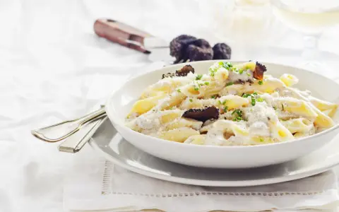 Penne cremose con funghi e tartufo nero, un piatto di pasta alla norcina che invita alla degustazione.