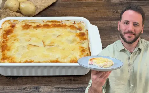 Una teglia fumante di parmigiana di patate, dorata e invitante, con una porzione servita su un piatto.