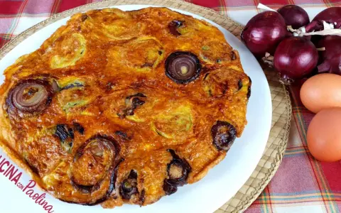 Frittata di pane dorata con cipolle rosse, uova e ingredienti freschi.