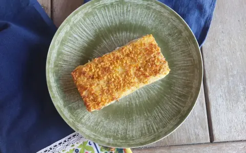 Delizioso merluzzo in friggitrice ad aria, croccante e dorato, servito su un piatto verde.