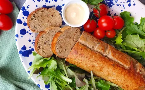 Un gustoso polpettone di tonno affettato, servito con pomodorini, insalata fresca e una ciotolina di maionese.