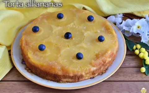 Deliziosa torta rovesciata all'ananas, con fette di ananas caramellate e mirtilli freschi, pronta per essere gustata.